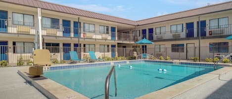 A pool area with a 3ft 9in depth, lounge chairs, and a covered seating area.