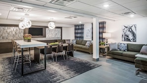 Una sala moderna con comedor, sofá y televisor.