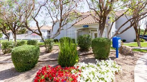 A building with a sign labeled "OFFICE" in front, surrounded by well-maintained landscaping including hedges and flower beds. - Studio 6 Tempe, AZ (Tempe)