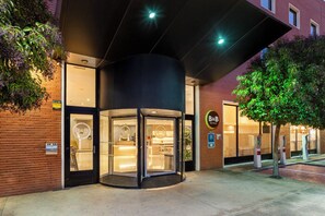 A hotel entrance with a revolving door, a sign with 'B&B' logo, and a brick facade. - B&B Hotel Madrid Arganda (Arganda del Rey)