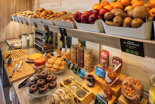 A bakery display with various baked goods, fresh fruits, and condiments. - B&B Hotel Madrid Arganda (Arganda del Rey)