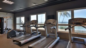 Une salle de sport équipée de tapis de course, d’un vélo d’appartement et d’un appareil d’aviron.