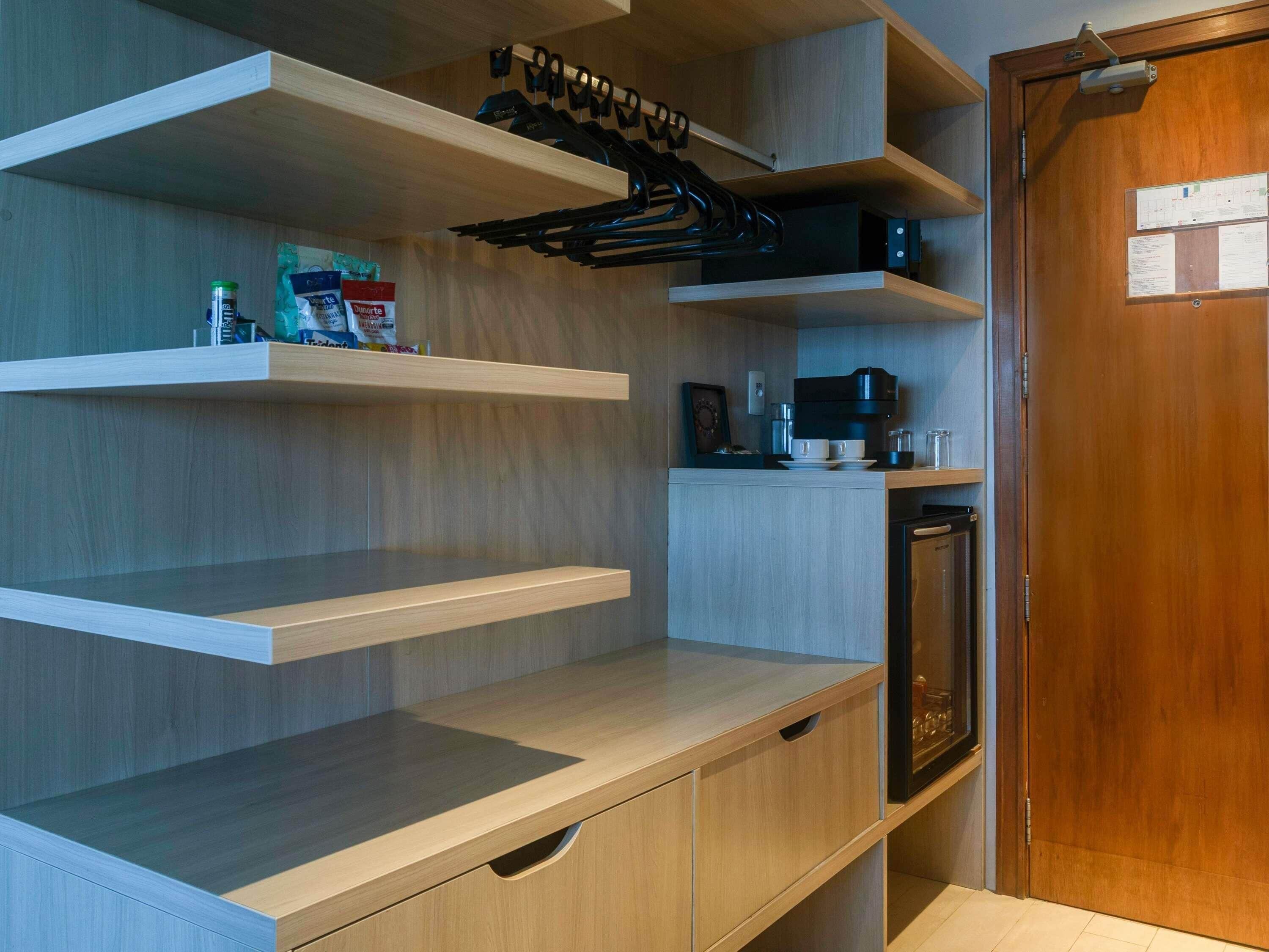 Une cuisine moderne avec des meubles en bois, une machine à café et un four encastré.