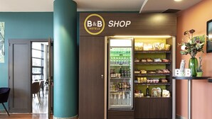 A B&B shop with a refrigerated display and shelves stocked with snacks and beverages. - B&B HOTEL Pisa Airport (Pisa)