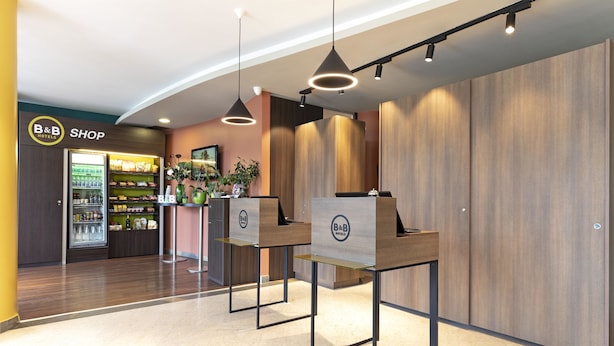 A B&B shop with a refrigerated display and a counter with a plant. - B&B HOTEL Pisa Airport (Pisa)