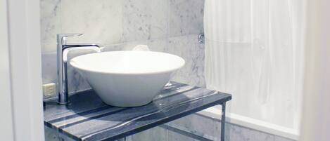 A bathroom with a white sink, a mirror, and a shower curtain.