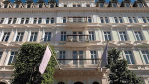 A historic building with classical architecture, featuring multiple balconies and arched windows.