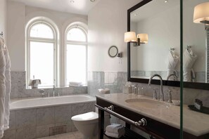 A modern bathroom with a large bathtub, a double vanity with two sinks, and a large mirror. - Elite Hotel Mollberg (Helsingborg)