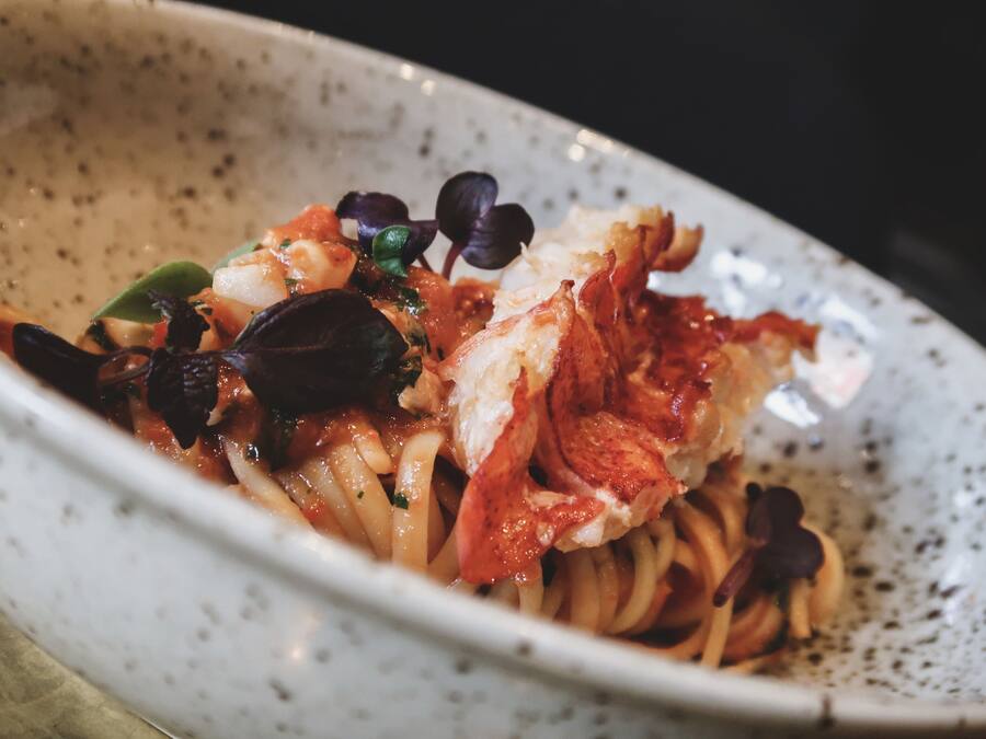 Een schaal pasta met zeevruchten en groenten.