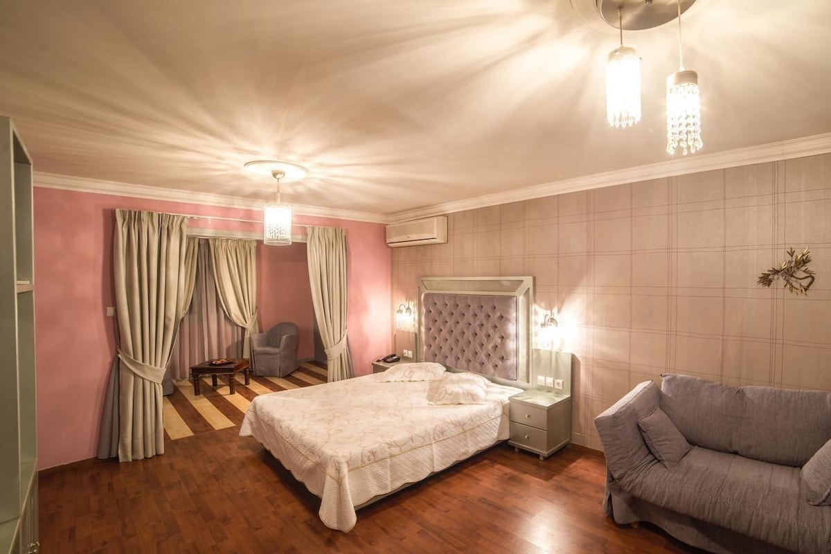 Une chambre à coucher comprenant un lit, une chaise, une table de chevet et une commode.