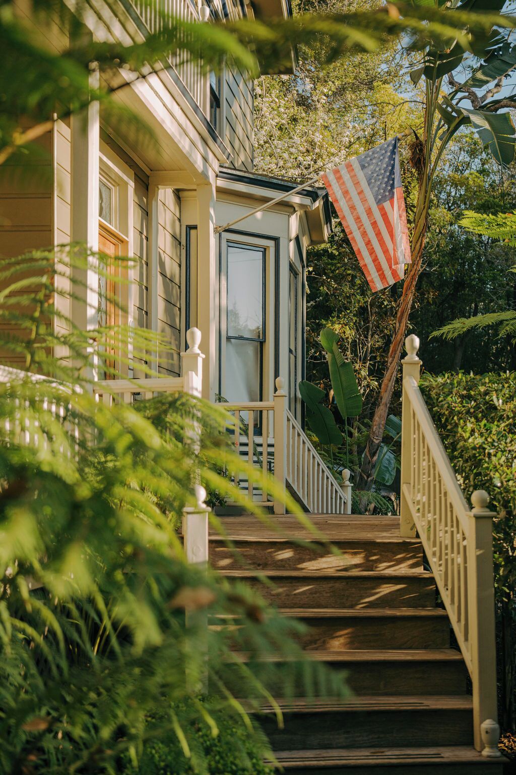 A wooden staircase leading to a house with a flag.