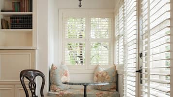 A cozy reading nook with a bench, a chair, and a bookshelf.