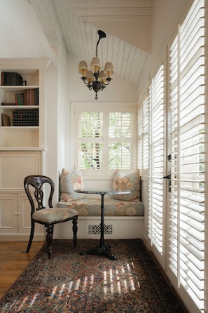 A cozy reading nook with a bench, a chair, and a bookshelf.