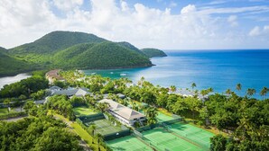 A resort with multiple tennis courts, a pool, and a view of the ocean and mountains. - Carlisle Bay (Carlisle Bay)