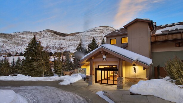 A hotel entrance with a snow-covered landscape and mountains in the background. - Marriott's StreamSide Birch at Vail (Vail)