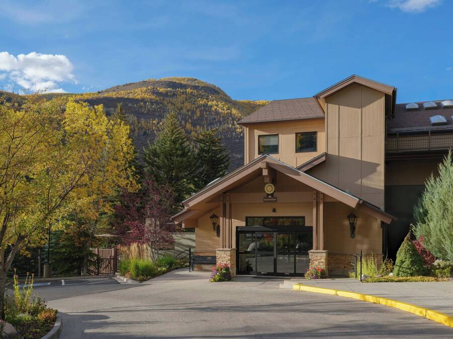 Un chalet à la façade en pierre, doté d’un porche et surplombant un paysage montagneux.
