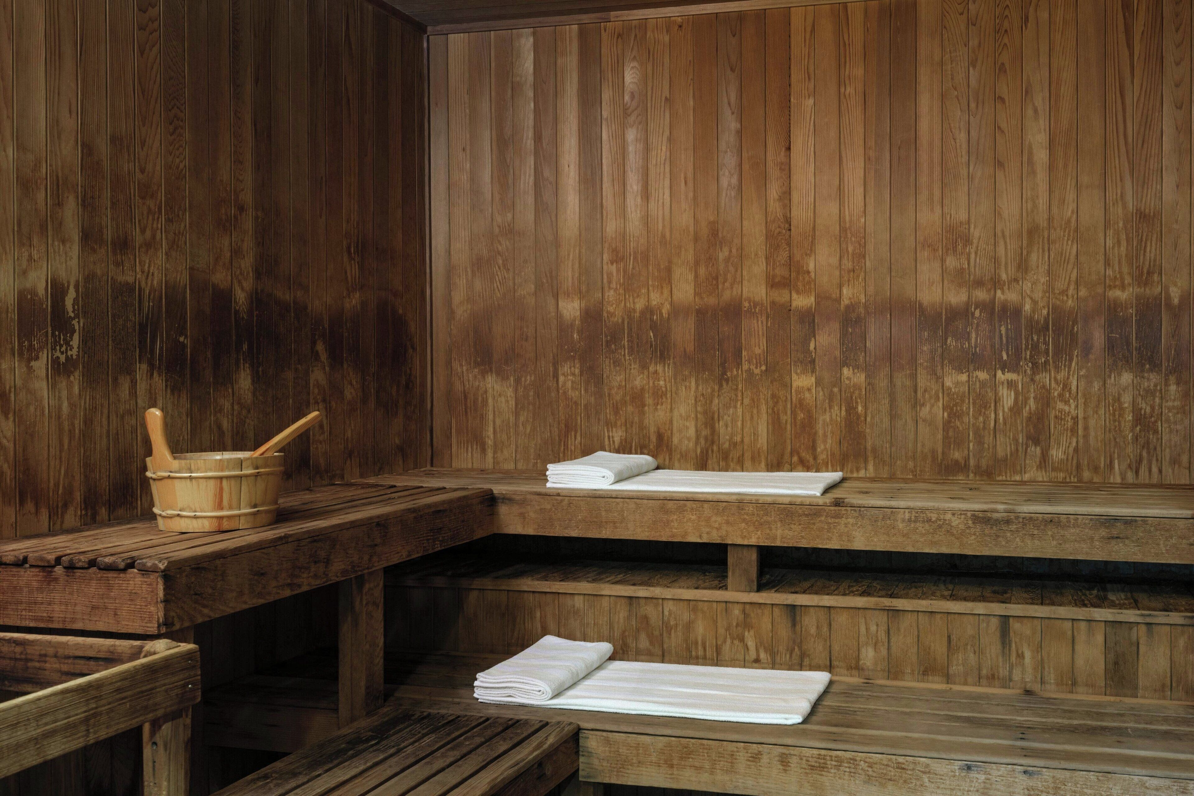 Una sauna de madera con bancos y un cubo de madera.