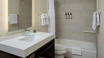 Een moderne badkamer met twee wastafels, een toilet en een bad.