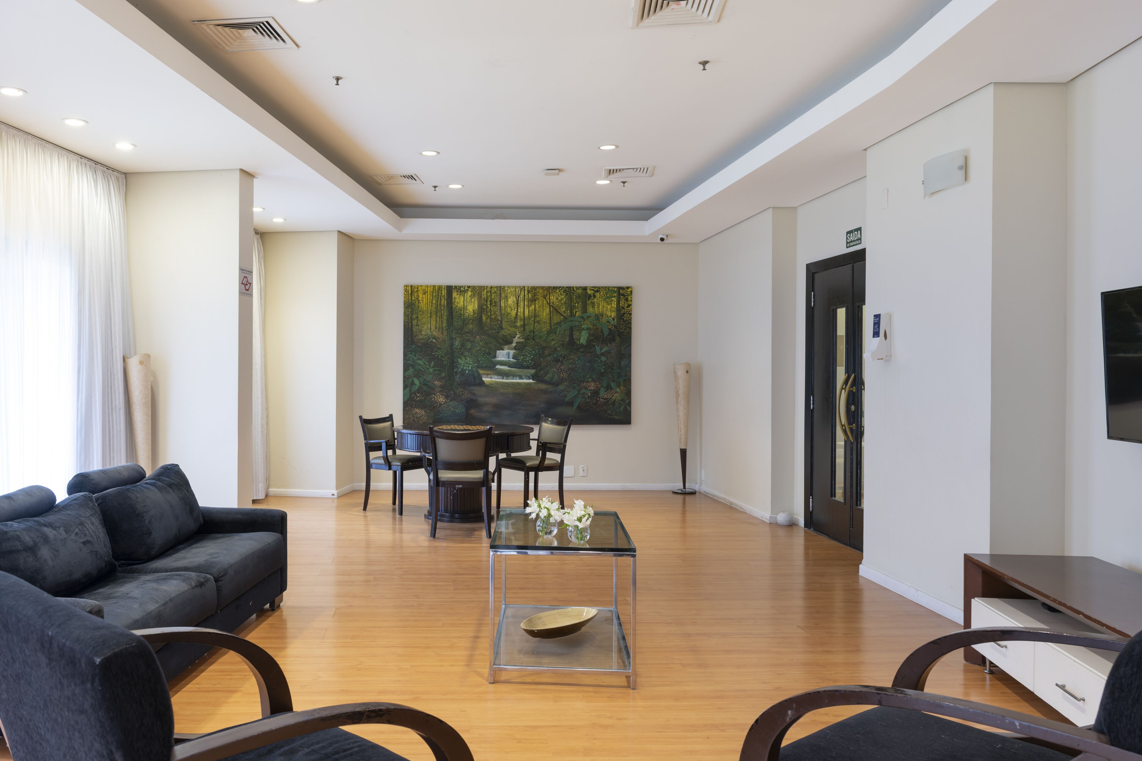 Una sala de estar moderna con un sofá, una mesa de centro de vidrio y un comedor con sillas y una mesa.