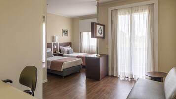 Una habitación de hotel con dos camas, un escritorio, una silla y un sofá.