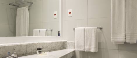 A modern bathroom with a marble sink, a toilet, and a towel rack.