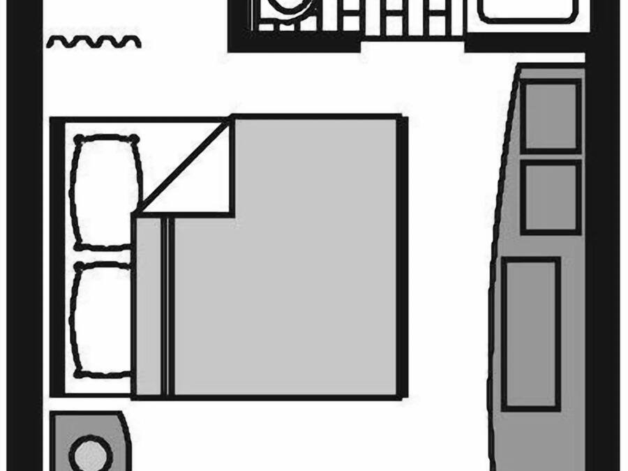Ein Zimmer mit Bett, Schreibtisch, Stuhl, Fenster und eigenem Badezimmer.