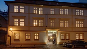 A hotel with a classic European architectural style, featuring multiple windows and a well-lit entrance. - Boutique Hotel BOOKQUET (Prague)
