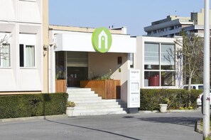 A modern building with a green logo, a staircase leading to the entrance, and a signboard with the word "Camparile". - Campanile Creteil Centre (Creteil)