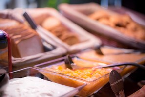 A buffet with various food options, including a fruit salad and other dishes. - Campanile Creteil Centre (Creteil)