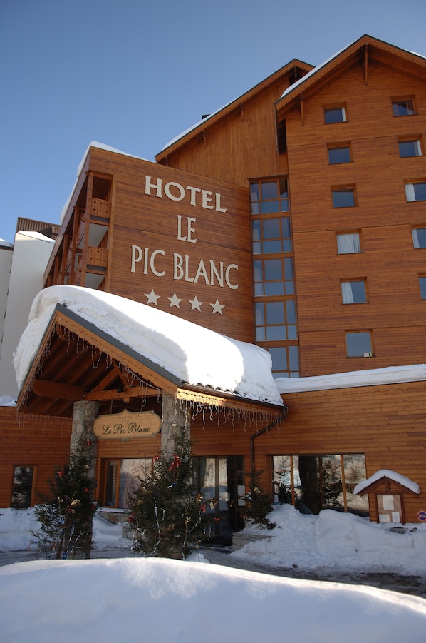 A wooden building with a sign reading "HOTEL LE PIC BLANC". - Hôtel Le Pic Blanc (Huez)