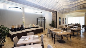 Un comedor moderno con una barra larga, varias mesas y sillas.