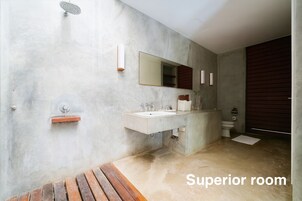 Un baño con un espejo grande, un lavamanos, inodoro y ducha.