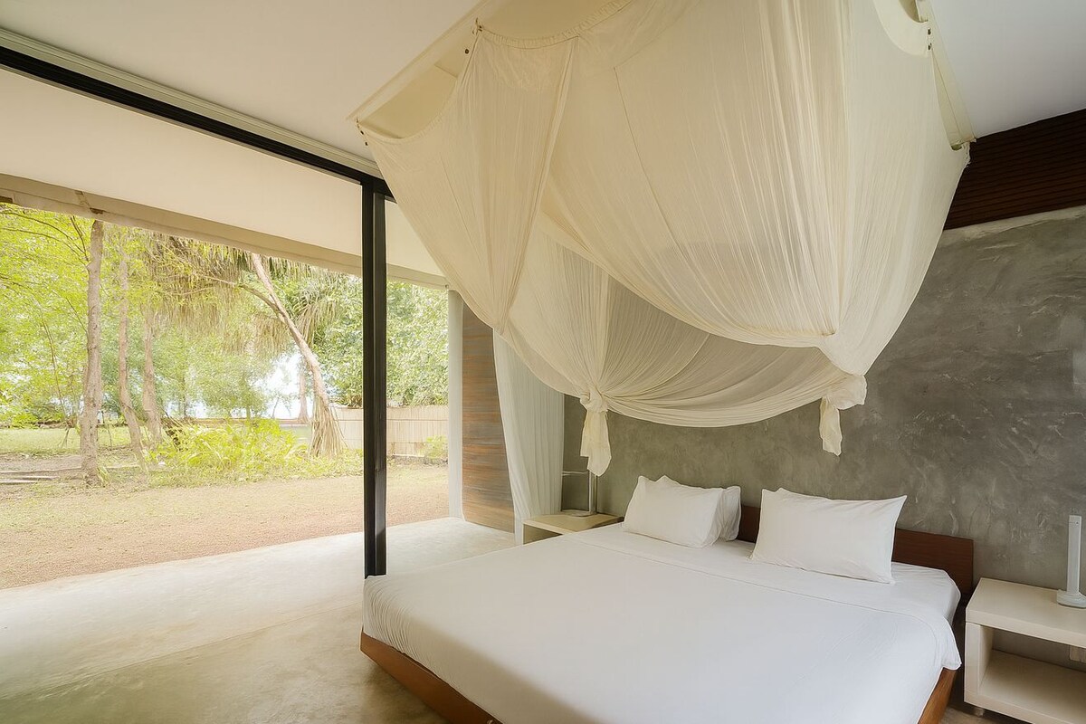A superior room with a large bed, a nightstand, and a canopy bed.