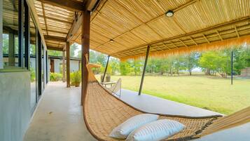 Suite frente a la playa con hamaca, mesa y vistas al exterior.