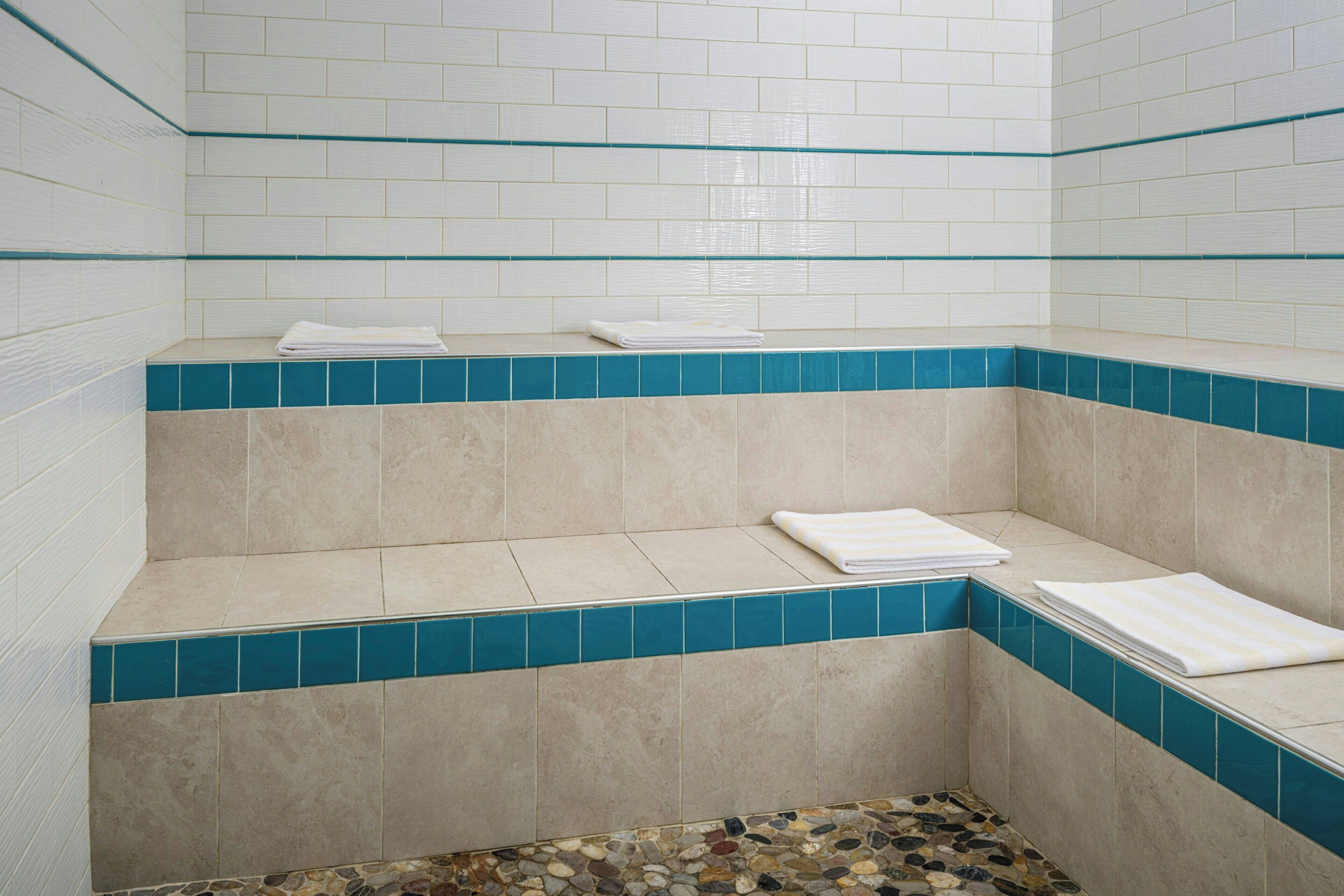 Un área de spa con un banco y piso de baldosas.