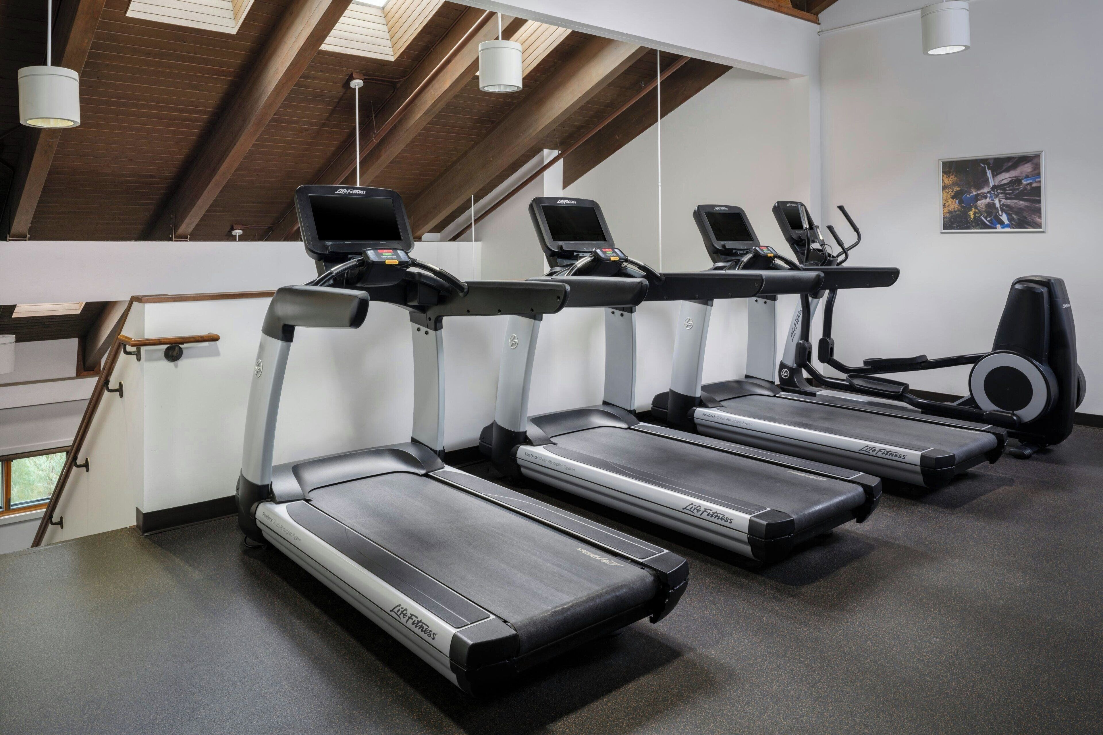 Ett gym med löpband, crosstrainers och en motionscykel.