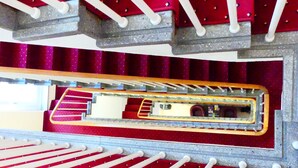 Ein Modell eines Theaters mit roten Sitzen, einer zentralen Gasse und einer Bühne.