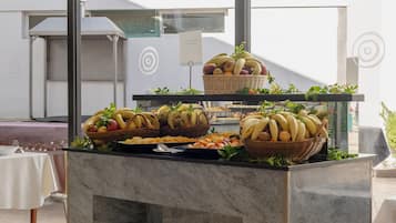 Un comptoir de buffet où sont présentés divers fruits et légumes sur un plan de travail en marbre.