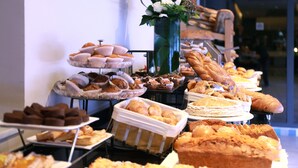 Un bufé con diversos productos horneados y pastelería.