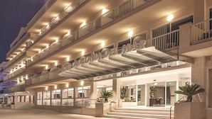 A hotel with multiple floors, a prominent entrance, and a well-lit facade. - Catalonia Del Mar - Adults Only (Son Servera)