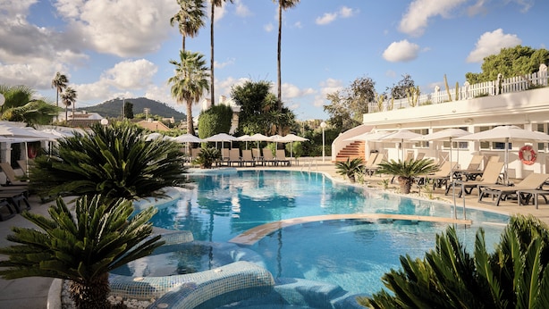 A pool area with lounge chairs, umbrellas, and palm trees. - Catalonia Del Mar - Adults Only (Son Servera)