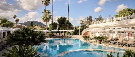 Una piscina cubierta, una piscina al aire libre, sombrillas, tumbonas