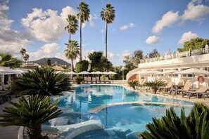 A pool area with lounge chairs, umbrellas, and palm trees. - Catalonia Del Mar - Adults Only (Son Servera)