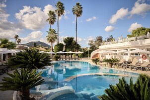 Una piscina techada, una piscina al aire libre, sombrillas