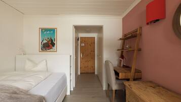 Quarto com cama, escrivaninha e cadeira.