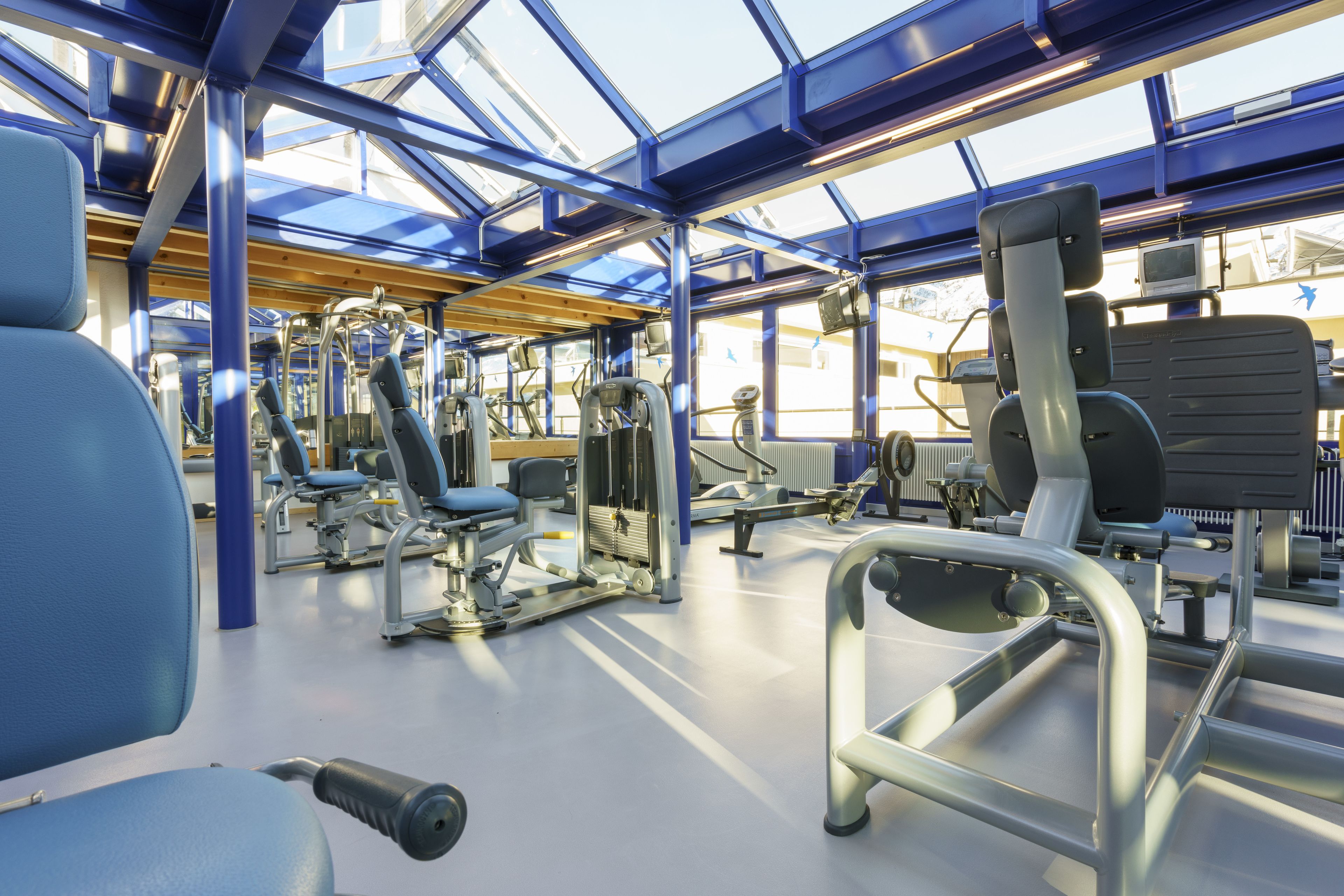 Een sportschool met trainingsapparatuur en een dakraam.