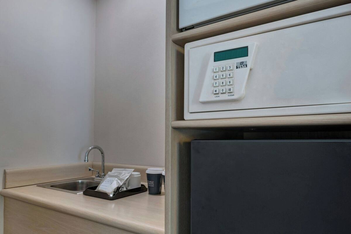 Une chambre d’hôtel équipée d’un four à micro-ondes, d’une machine à café et d’un évier.
