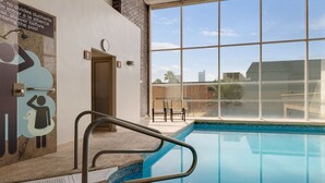 A swimming pool with a clear view of the sky and buildings in the background.