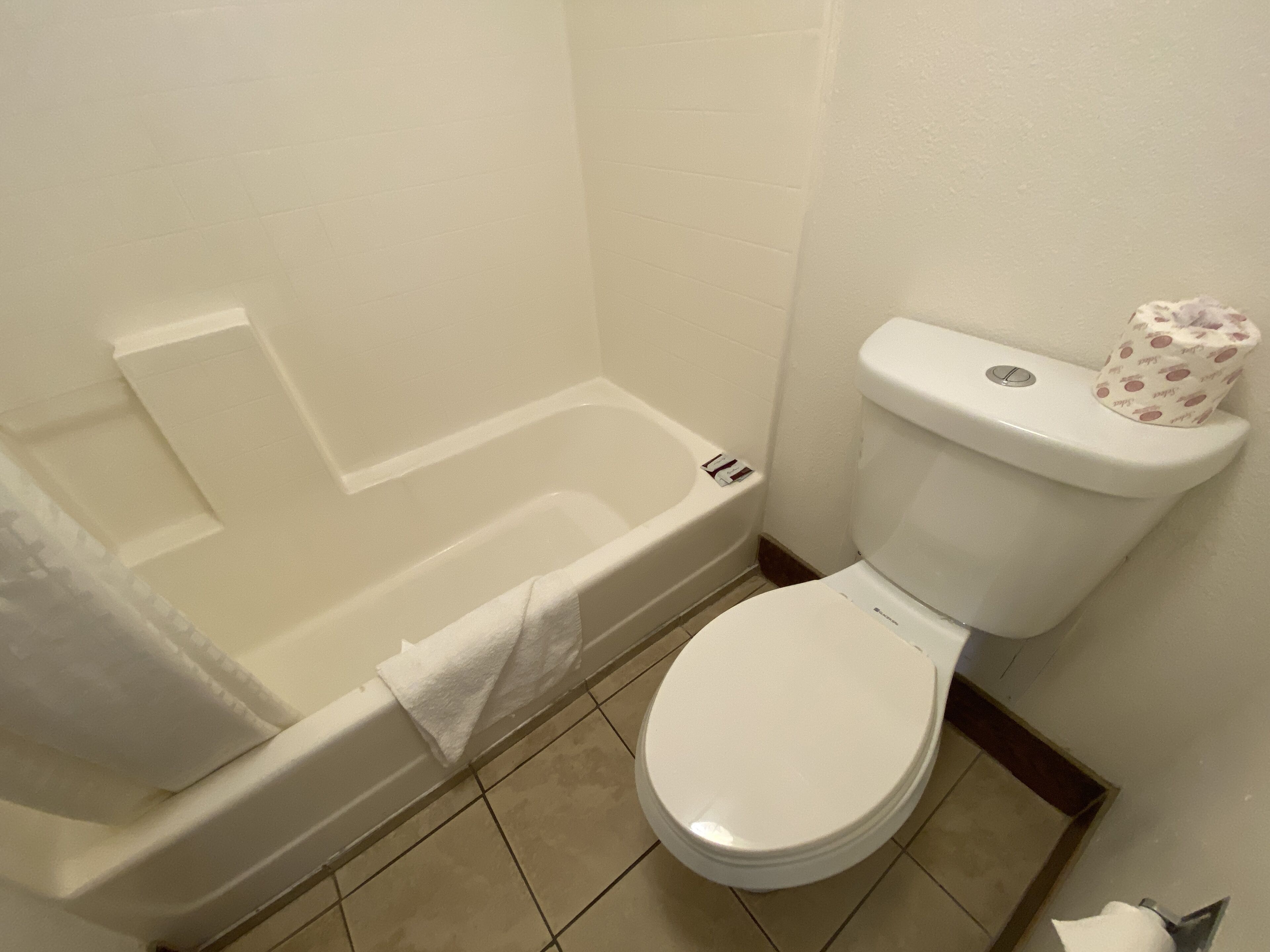 Un baño con bañera, inodoro y un perchero para toallas.