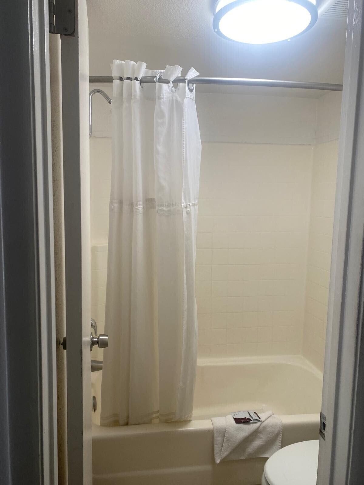 Un baño con bañera, inodoro y cortina de ducha.